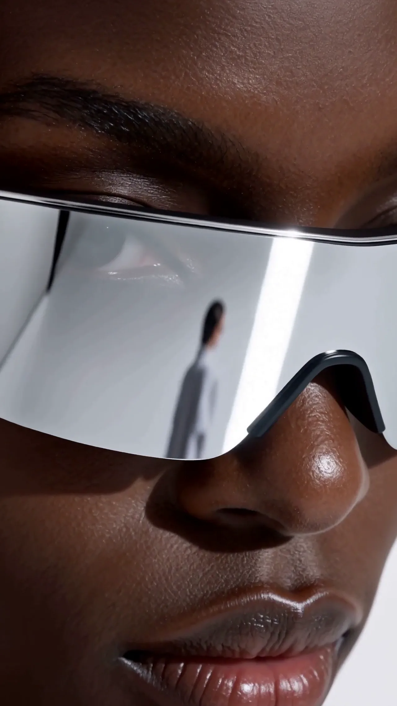 Close portrait of a person wearing a mirrored futuristic visor